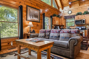 Step into your cozy mountain retreat where rustic charm meets comfort. Sunlight streams through tall windows, warming the open living space with its inviting wood accents and plush seating.