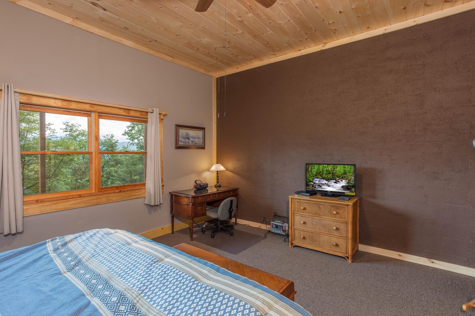 King bed facing dresser with tv and small desk