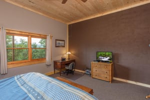 King bed facing dresser with tv and small desk