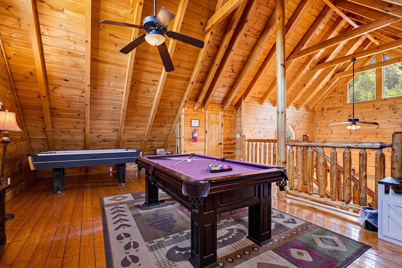 Gather in your own private game loft with soaring vaulted ceilings, polished wood finishes, and endless fun—billiards, air hockey, and mountaincabin charm all await.