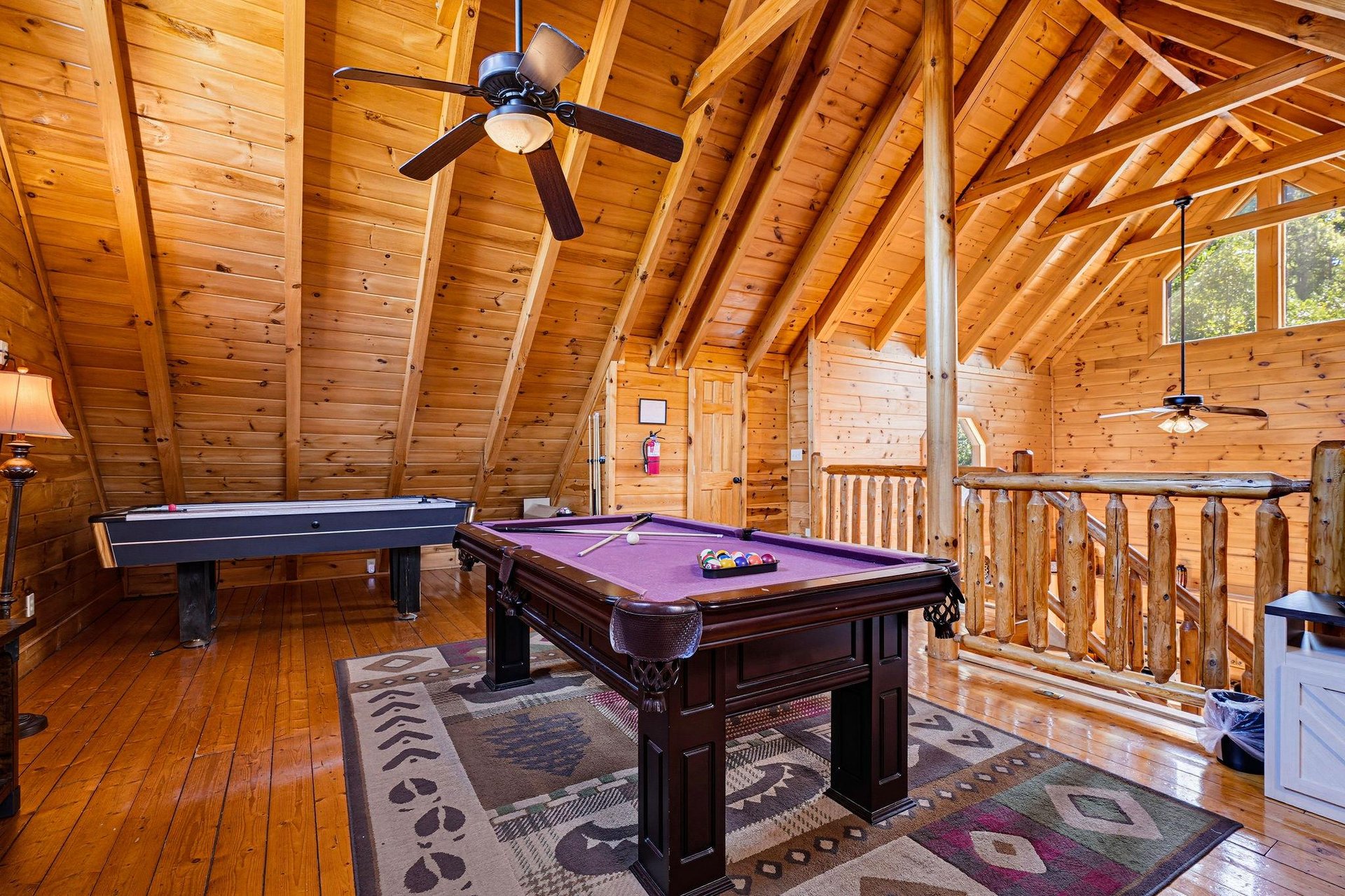 Gather in your own private game loft with soaring vaulted ceilings, polished wood finishes, and endless fun—billiards, air hockey, and mountaincabin charm all await.