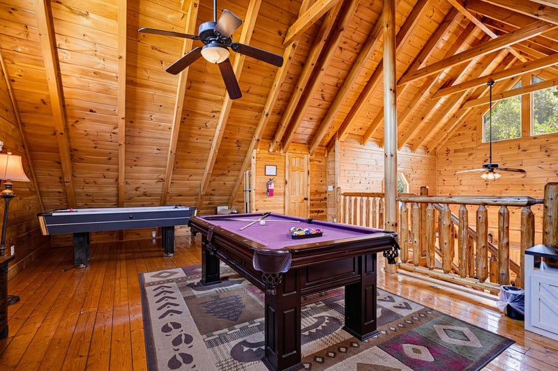 Gather in your own private game loft with soaring vaulted ceilings, polished wood finishes, and endless fun—billiards, air hockey, and mountaincabin charm all await.