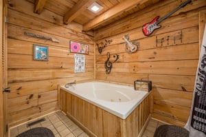 Soak away your stress in this musicthemed cabin bathroom, where rustic wood walls and whimsical décor create your perfect retreat sanctuary.