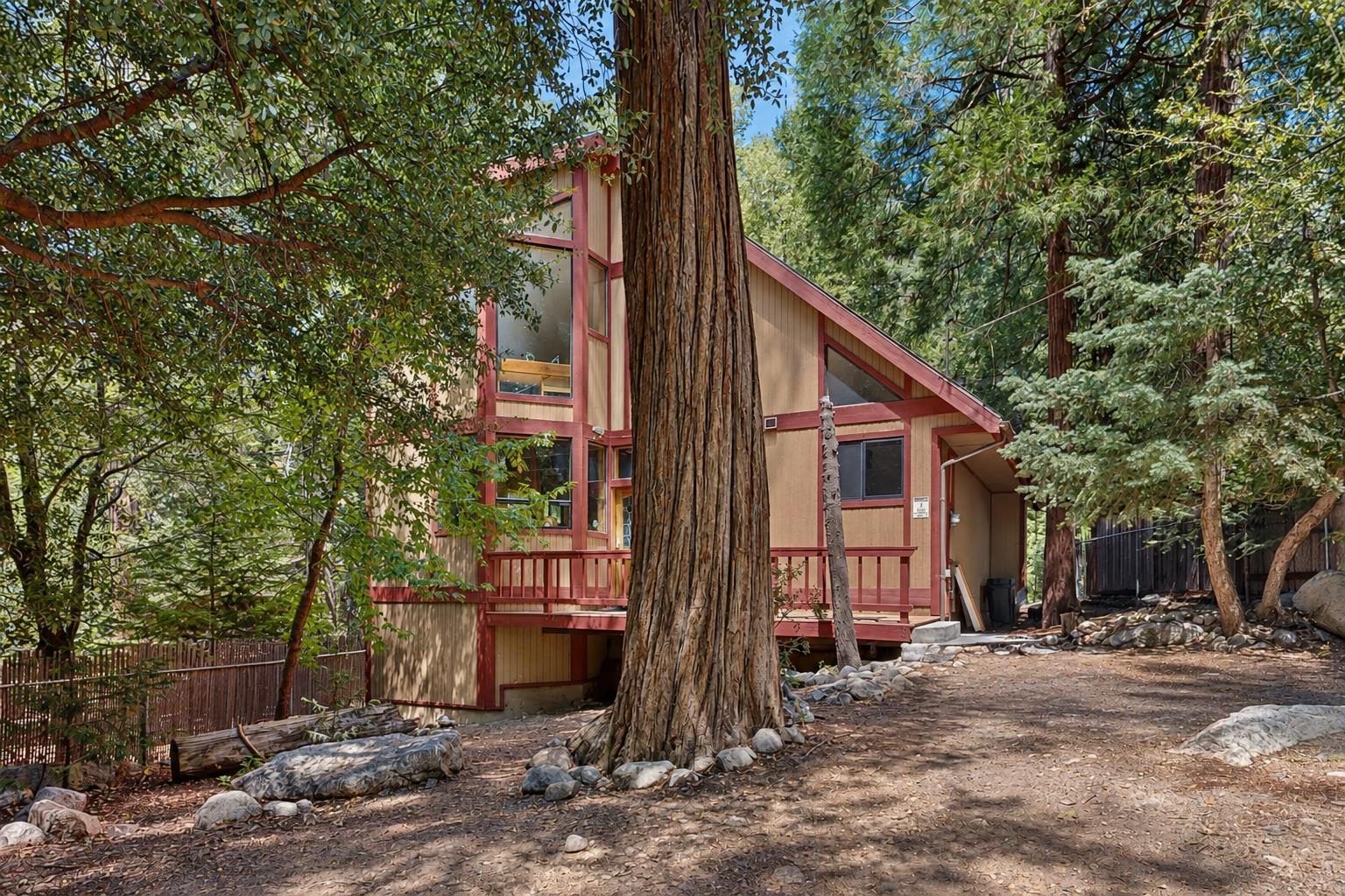 Strawberry Creek Cabin sits nestled among oldgrowth pines and redwoods, its Aframe design and red trim blending right into the forest setting.