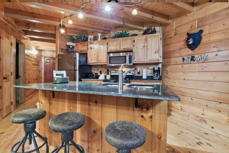 Step into your rustic mountain kitchen where granite counters meet warm wood beams, creating the perfect space for morning coffee and meal prep.