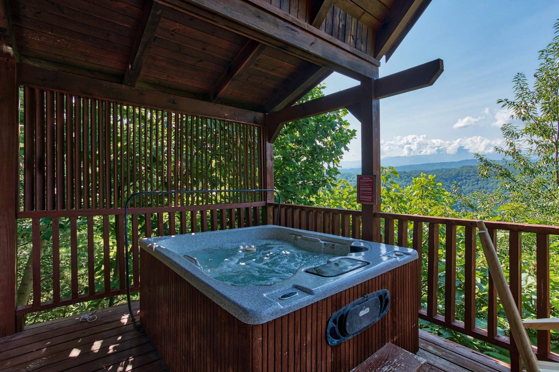 hot tub on a covered deck with mountain views at angels majestic view a 3 bedroom cabin rental located in pigeon forge