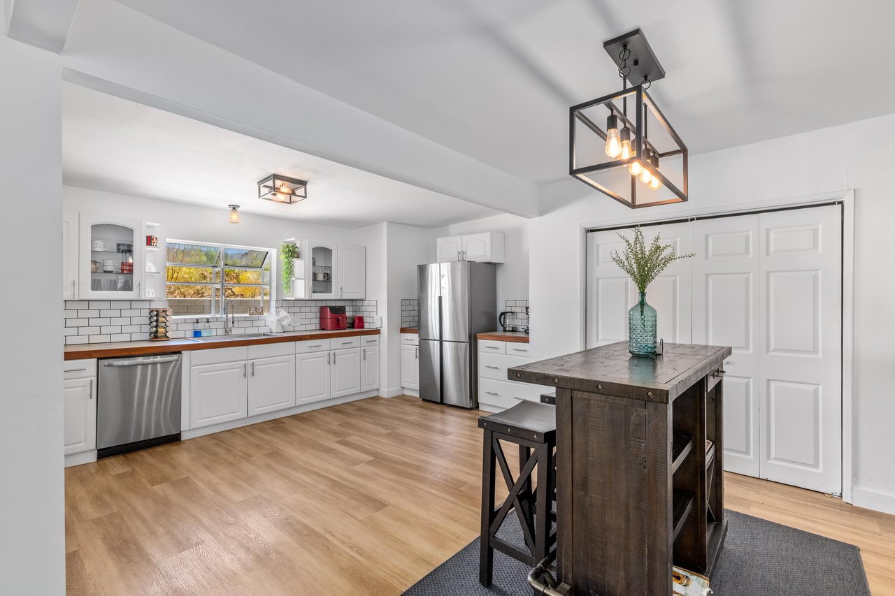 Stainless steel appliances, cooking essentials, and barheight table.