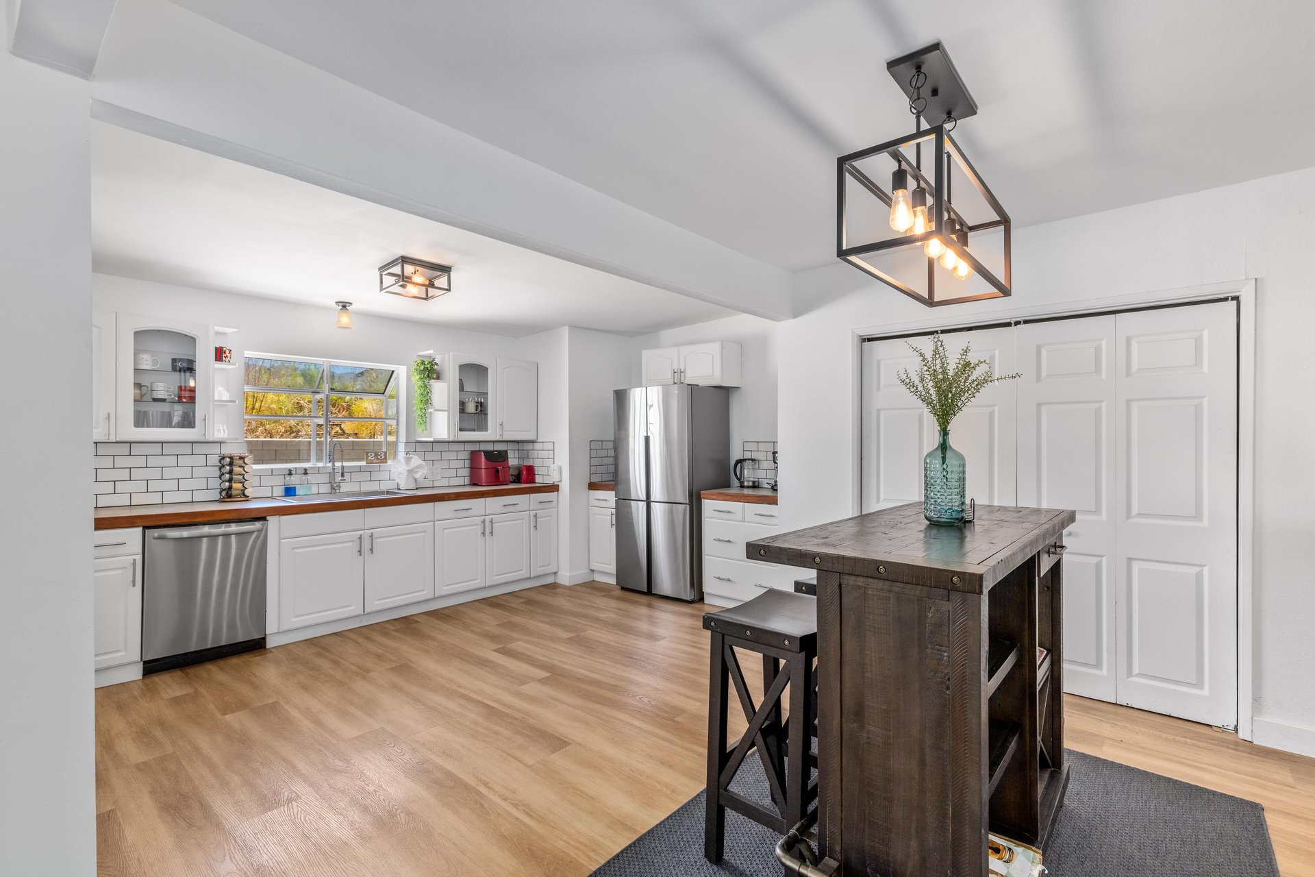Stainless steel appliances, cooking essentials, and barheight table.