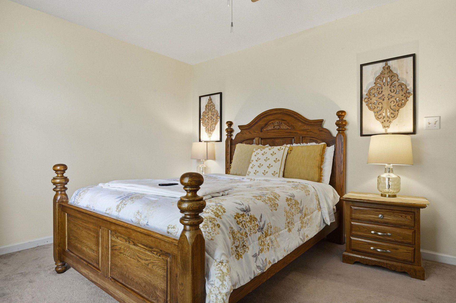 Settle into your peaceful retreat featuring a stately fourposter bed dressed in elegant linens, soft lighting, and charming artwork that creates a warm, restful atmosphere.