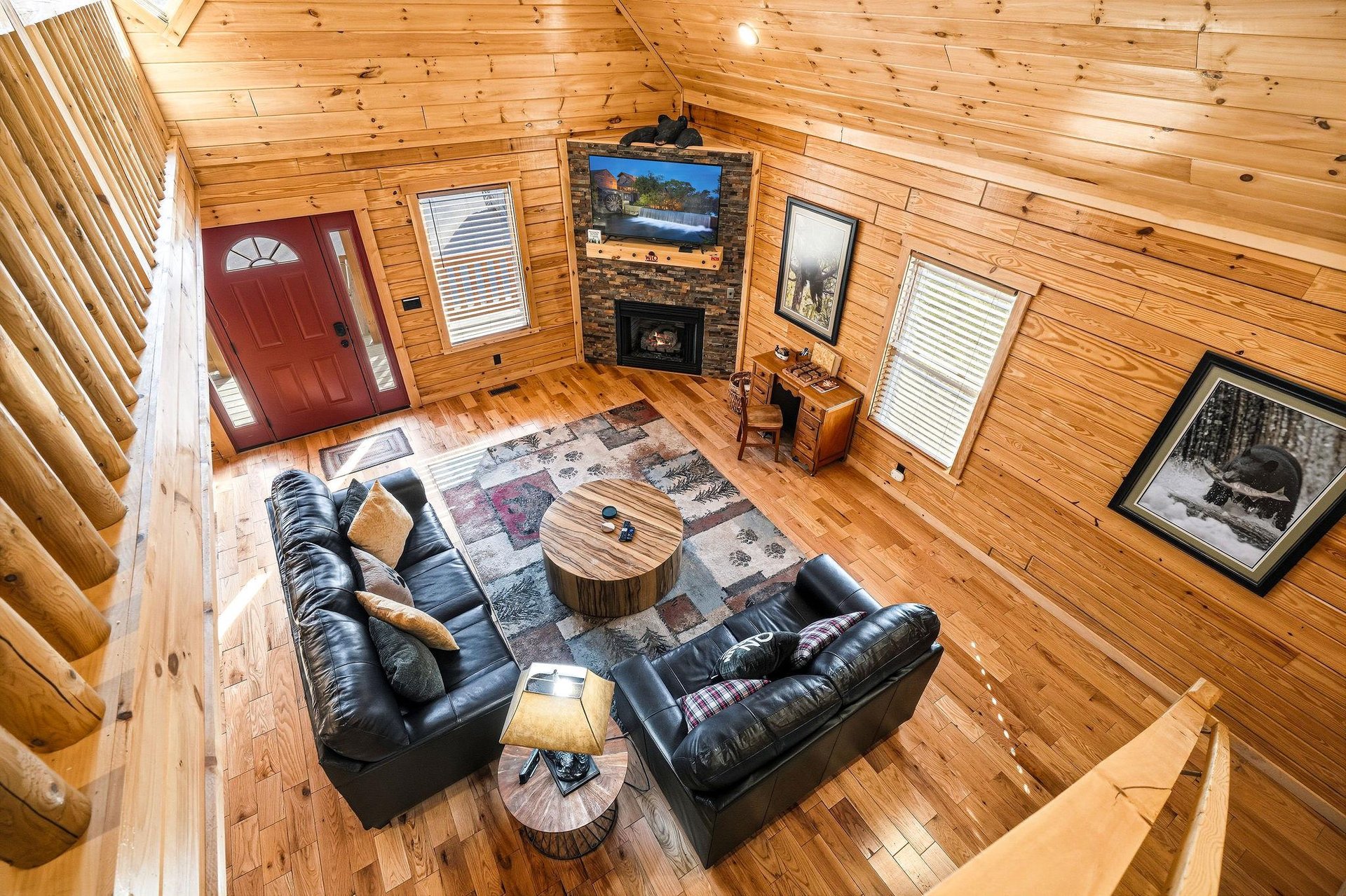 Relax in your cozy cabin living room with plush leather seating, crackling fireplace, and warm wood walls creating the perfect mountain retreat.