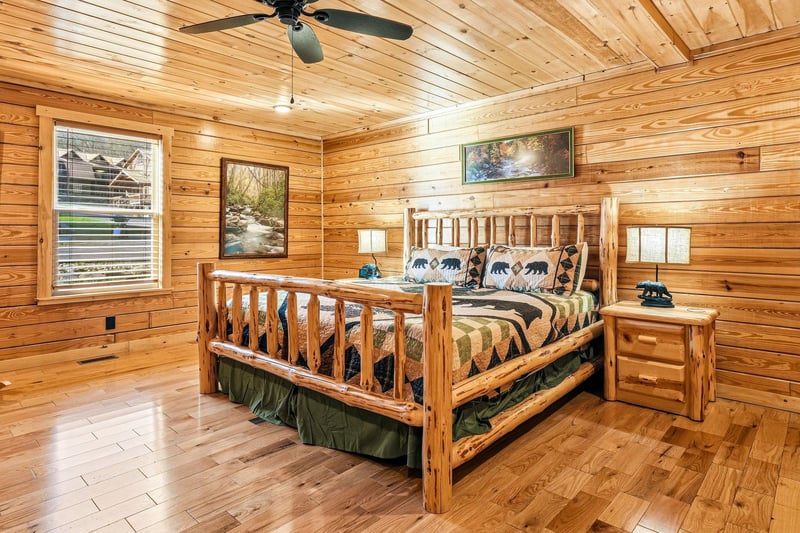 Drift off to sleep in this rustic log cabin bedroom where warm wood surrounds you and cozy bearthemed bedding awaits your arrival.