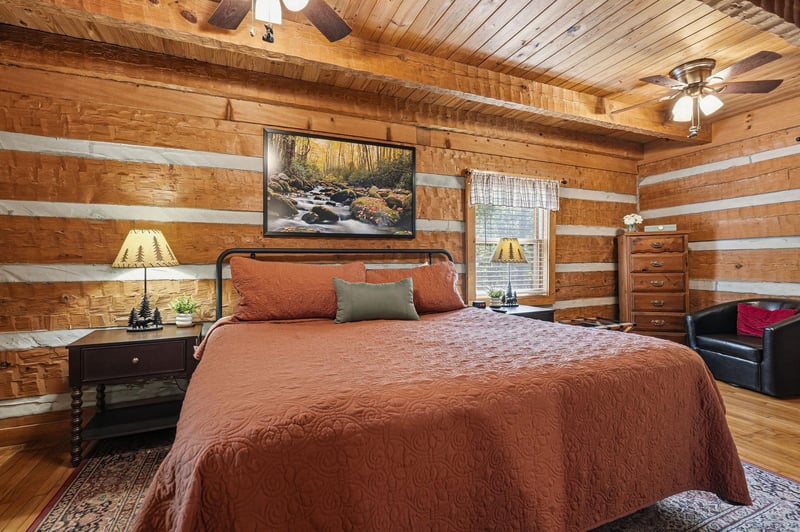 Your charming log cabin bedroom awaits with rustic wood beams, warm lighting, and a cozy bed where you can unwind after exploring the surrounding nature trails.