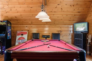 Challenge your friends to a friendly game of pool in the rustic game room, with vaulted wood ceilings and arcade entertainment for endless fun.