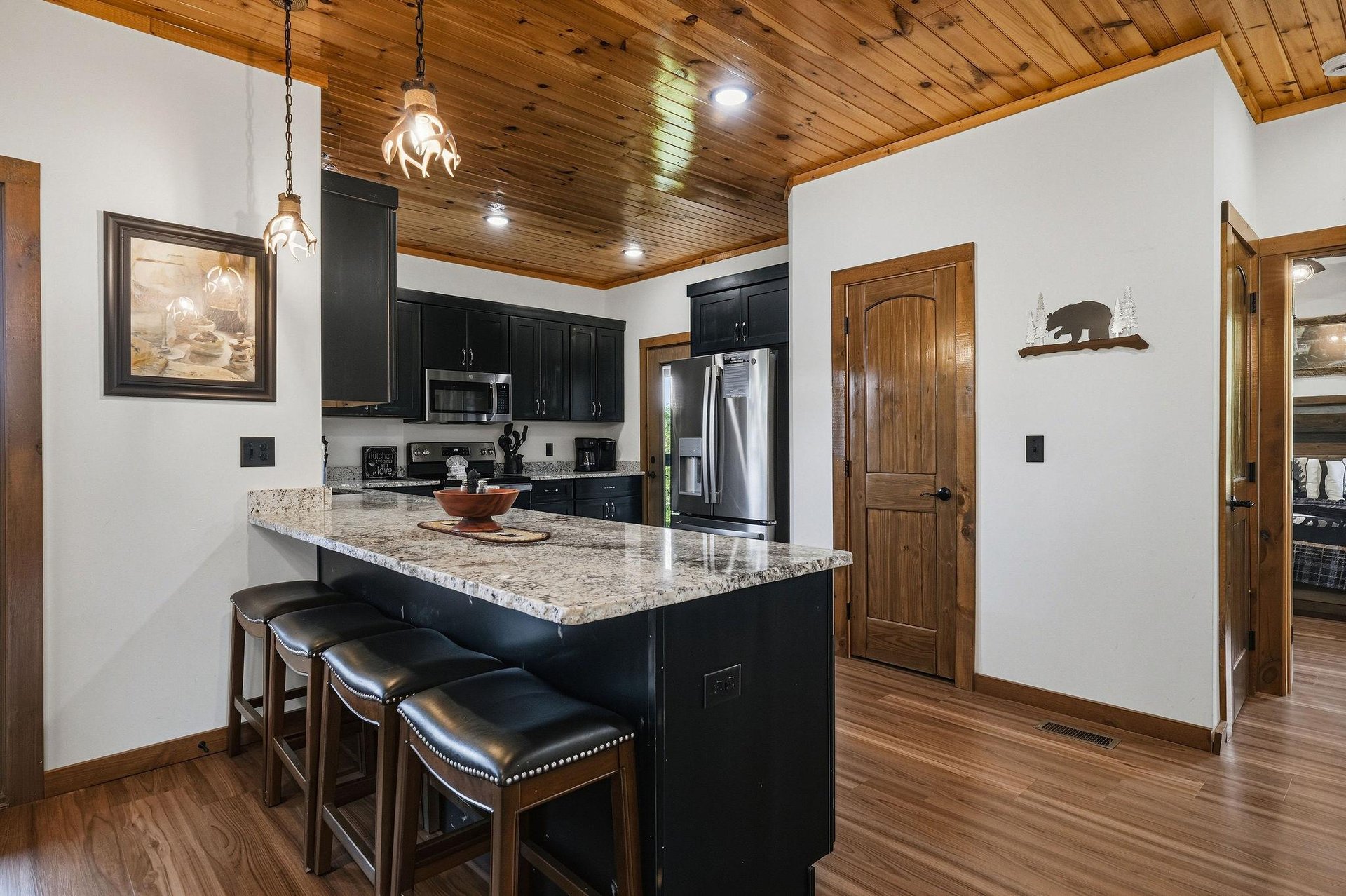 Gather around the island in your fully equipped kitchen, where granite countertops and stainless steel appliances set the stage for your mountain getaway meals. Warm wood ceilings and rustic touches c