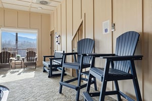 Relax in comfortable seating while enjoying mountain views through large windows in this inviting indooroutdoor space.