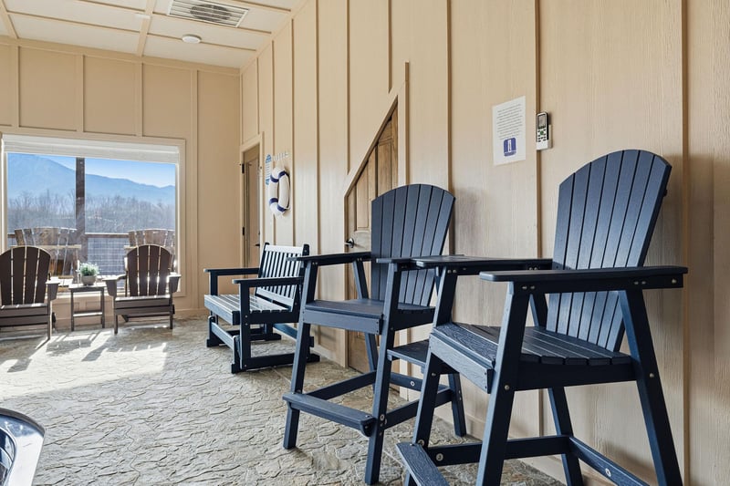Relax in comfortable seating while enjoying mountain views through large windows in this inviting indooroutdoor space.