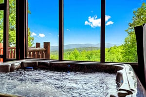 Sink into bubbling warmth while you gaze at rolling mountain peaks and lush forest—pure bliss right from your own private hot tub.