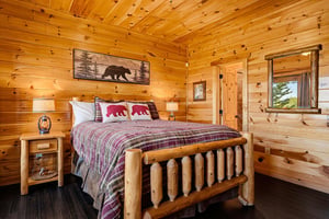 Cozy up in this charming cabin bedroom wrapped in warm pine, featuring a handcrafted log bed and wildlifeinspired touches that bring the mountain home. Your woodland retreat awaits.