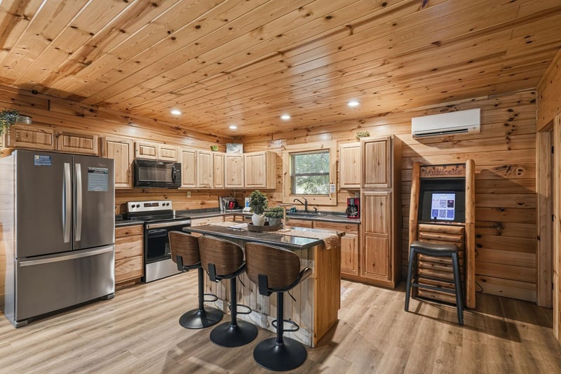 Gather around the spacious kitchen island with stainless steel appliances, granite countertops, and warm knotty pine finishes welcoming you to cook, share meals, and create lasting memories in this co