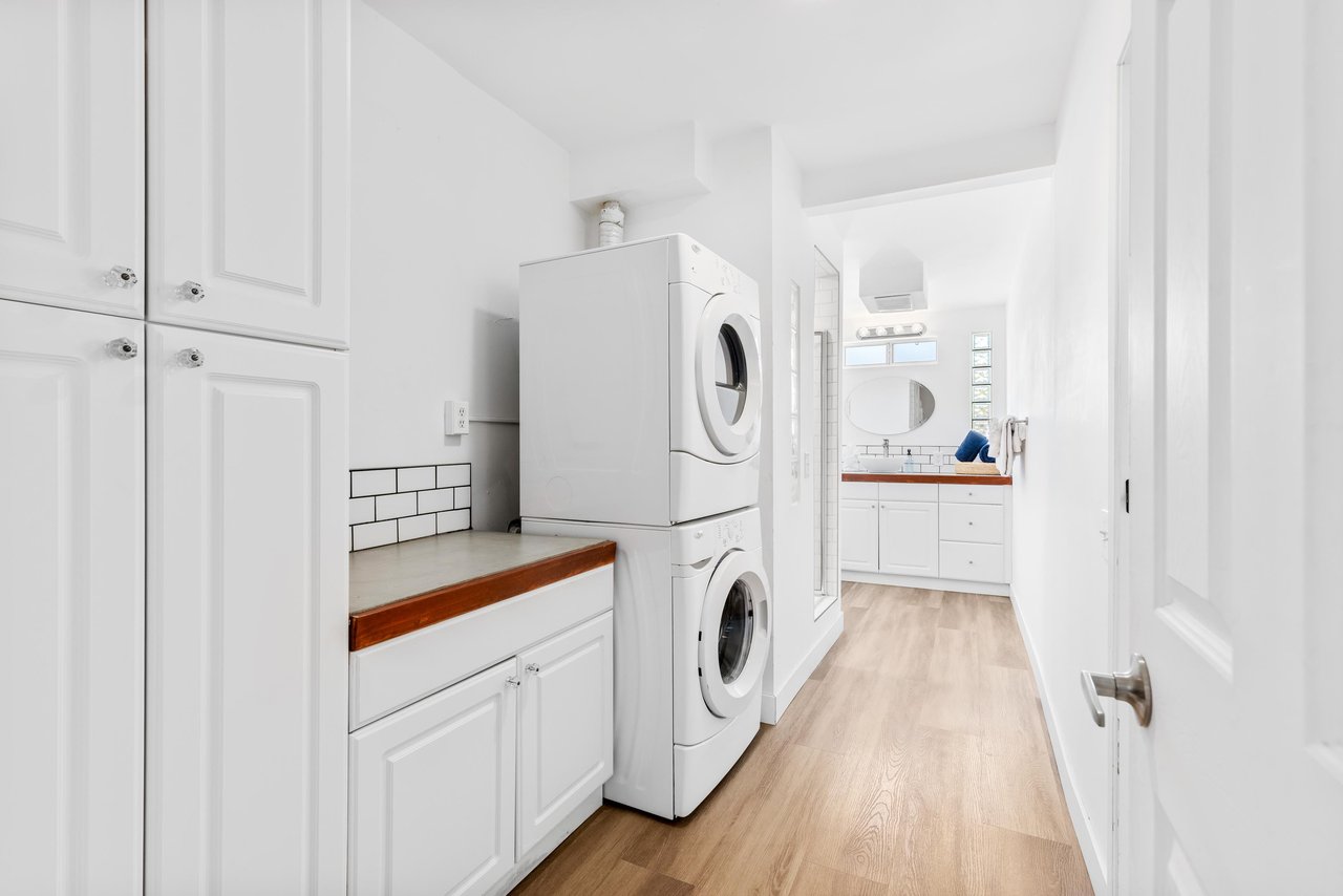Guest bathroom with stand alone shower and washerdryer for guest use.
