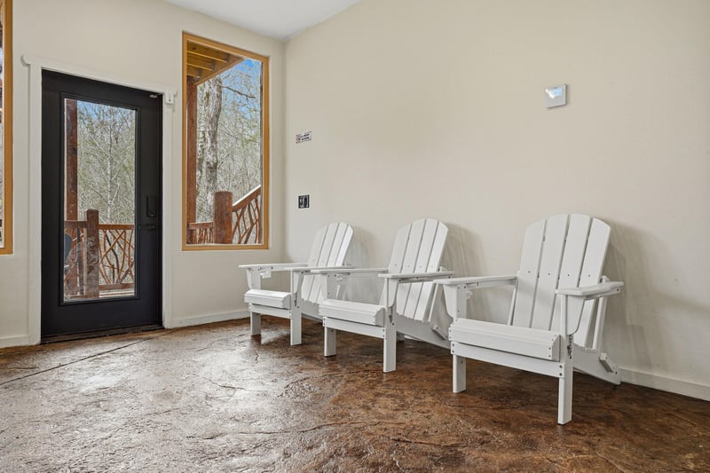 Settle into these comfortable Adirondack chairs on your private covered porch, where peaceful forest views create the perfect backdrop for morning coffee or evening relaxation.