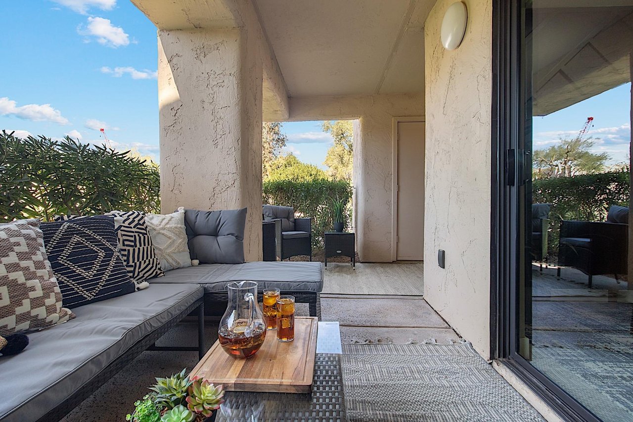 Private patio w Lshaped outdoor sofa, coffee table and two sitting chairs.