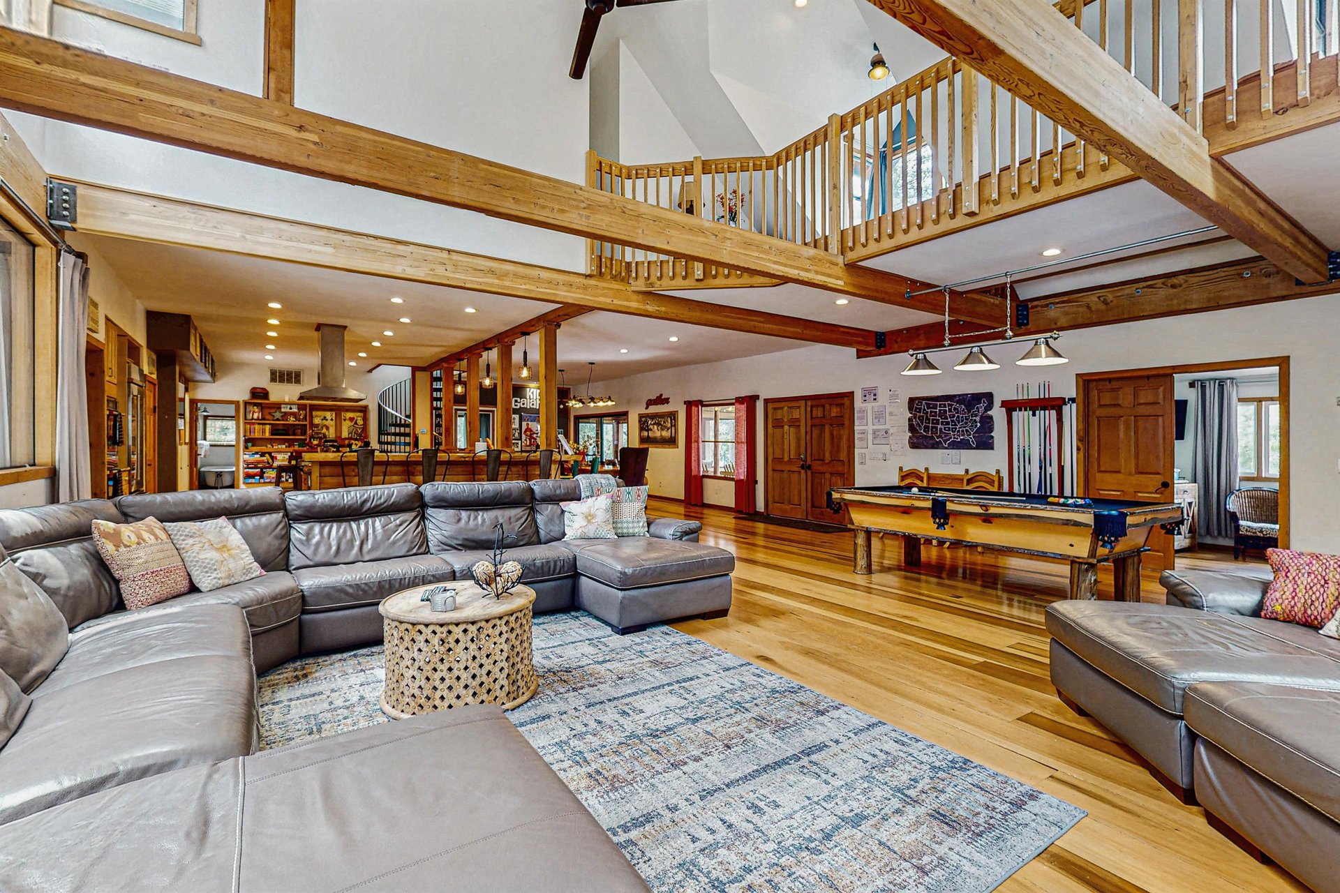 This massive open great room features a pool table, a chessgame table, and a huge wraparound sectional, with a loft overlooking the space above.