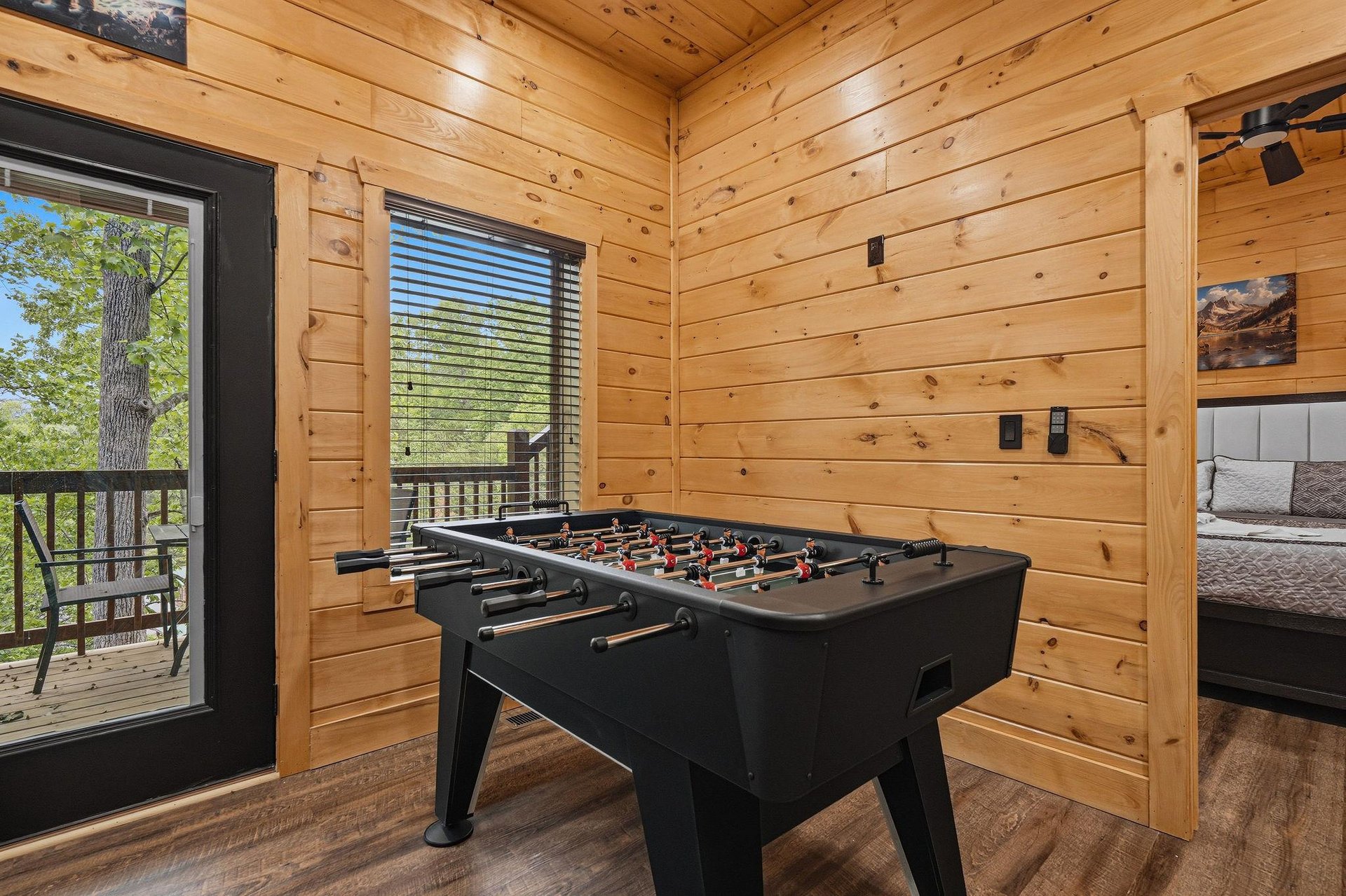 Challenge friends to a game of foosball in your cozy cabin retreat, where warm wood walls and forest views create the perfect atmosphere for fun.