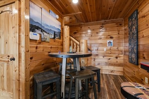 Gather around your private game table in this cozy cabin loft, where rustic wood beams and mountain artwork set the stage for memorable evenings of cards, conversation, and laughter.