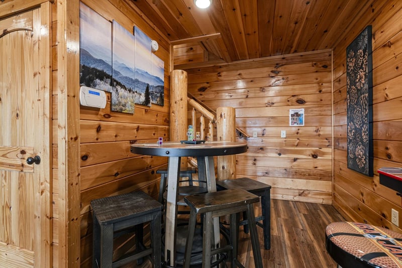 Gather around your private game table in this cozy cabin loft, where rustic wood beams and mountain artwork set the stage for memorable evenings of cards, conversation, and laughter.