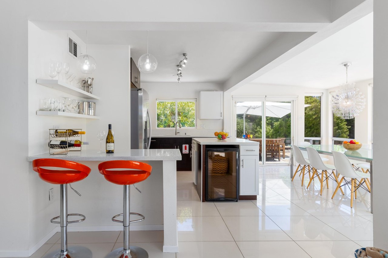 Kitchen is equipped with stainless steel appliances, counter seating for 2, wine fridge, and a spacious kitchen island.