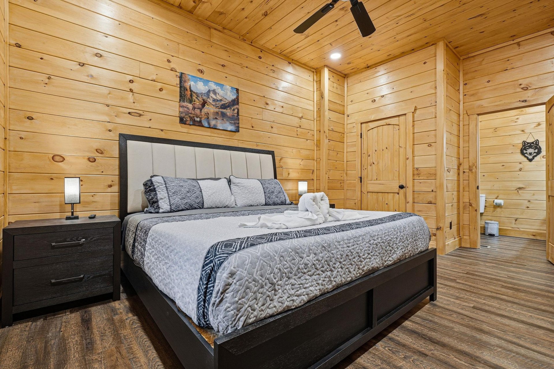 Drift off to sleep in your cozy cabin bedroom, where rustic wood walls and modern comfort create the perfect mountain retreat.