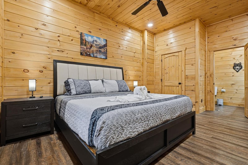Drift off to sleep in your cozy cabin bedroom, where rustic wood walls and modern comfort create the perfect mountain retreat.