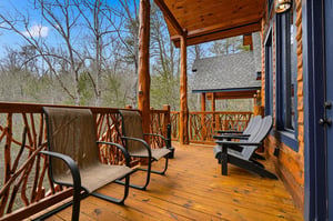 Relax on your private deck with comfortable seating, surrounded by peaceful wooded views and rustic charm.