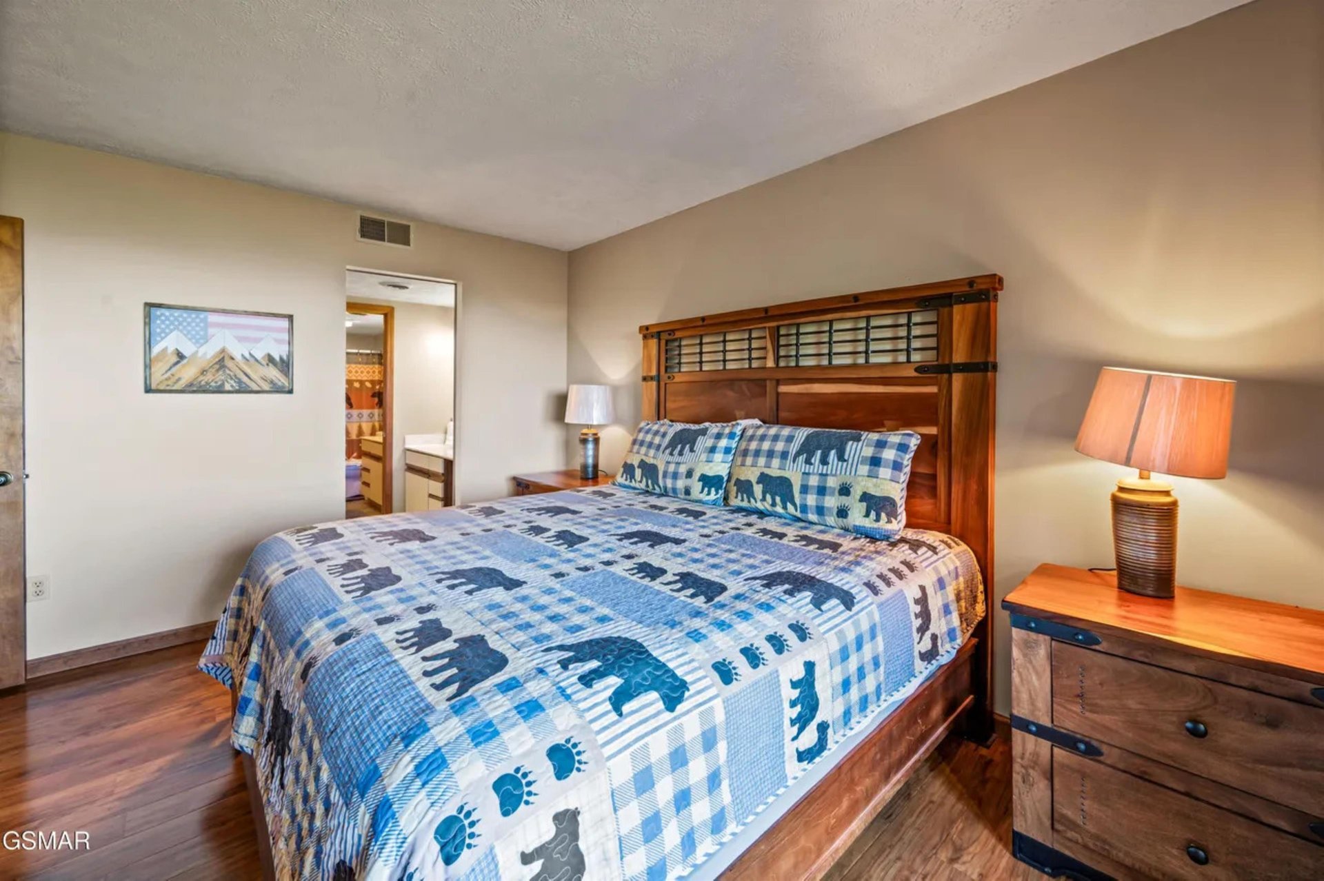 Youll love the rustic charm of this cozy bedroom, featuring a beautiful wooden headboard and charming bearthemed bedding that sets the perfect mountain getaway mood.