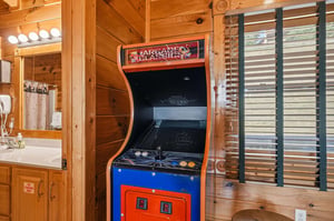 Challenge your friends to a classic arcade game in this cozy cabin retreat, where entertainment meets rustic charm in the heart of your getaway.