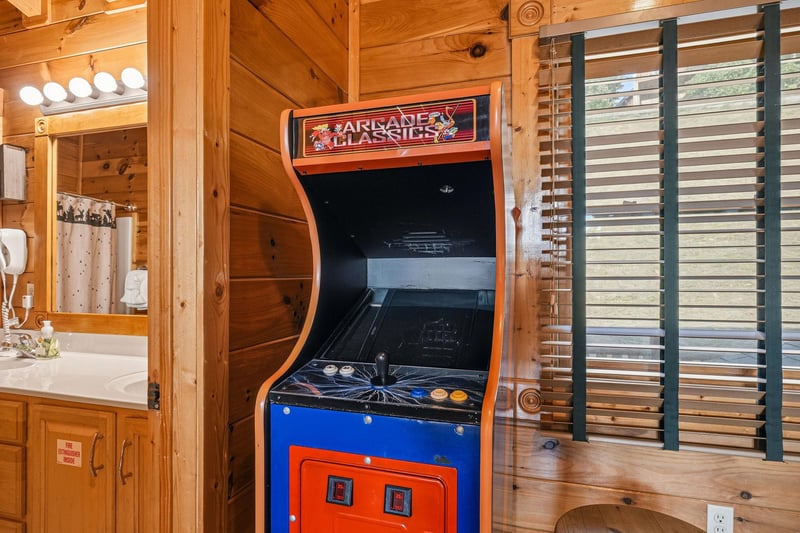 Challenge your friends to a classic arcade game in this cozy cabin retreat, where entertainment meets rustic charm in the heart of your getaway.