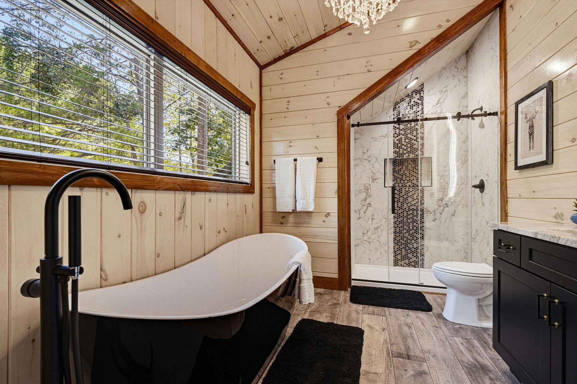 Soak in your elegant freestanding tub or refresh under the walkin shower, all while natural light pours through the window overlooking peaceful greenery.