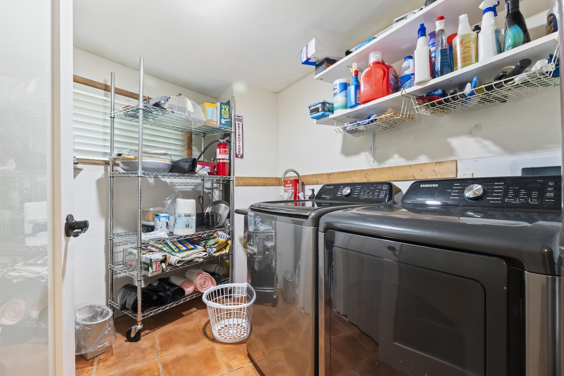 Laundry room with washerdryer access and cleaning supplies.