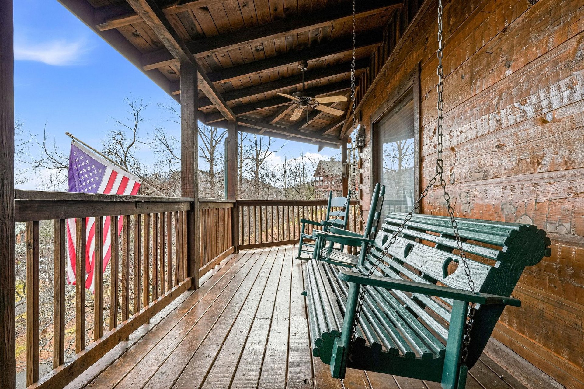 Settle into your private covered deck where rustic charm meets comfort—swing gently while enjoying peaceful wooded views.