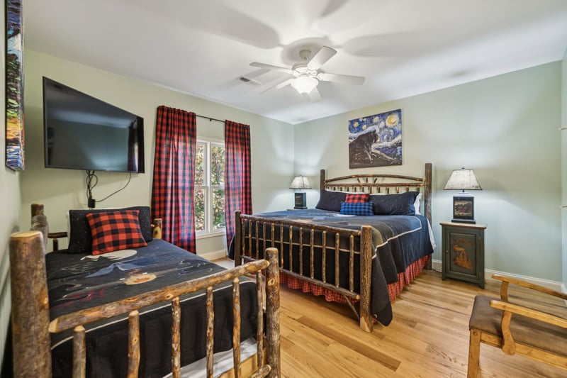 Rustic log beds and cozy plaid touches invite you to unwind after a day of adventure. Your private retreat features a ceiling fan, flatscreen TV, and warm hardwood floors for ultimate comfort.