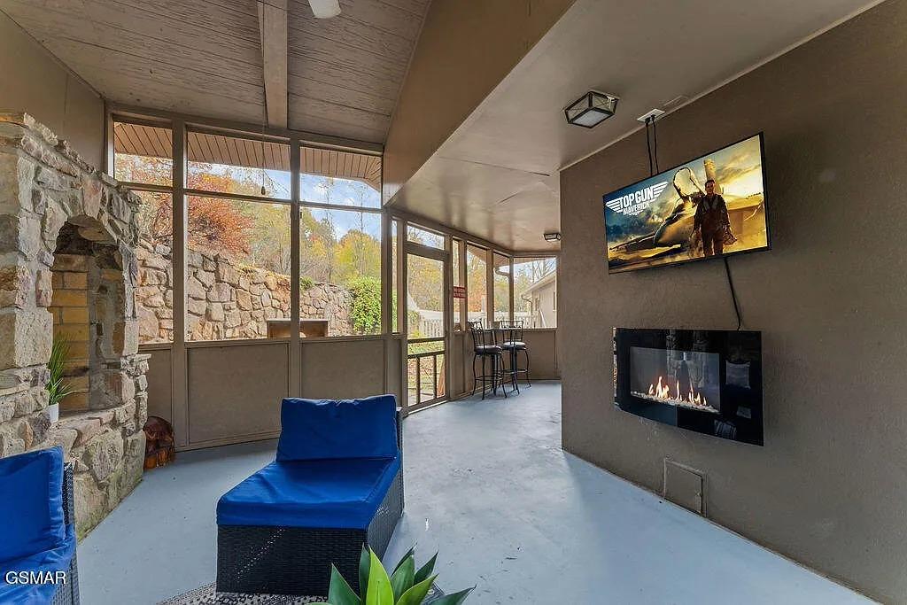 Unwind in your stylish lounge where stone meets sleek design—crackling fireplace warmth, cinematic entertainment, and serene views create perfect relaxation.