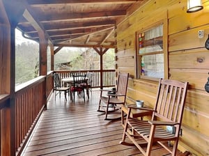 Unwind on your private deck with rocking chairs and a dining set, surrounded by peaceful mountain forest views—a perfect spot to sip morning coffee or enjoy evening conversations.