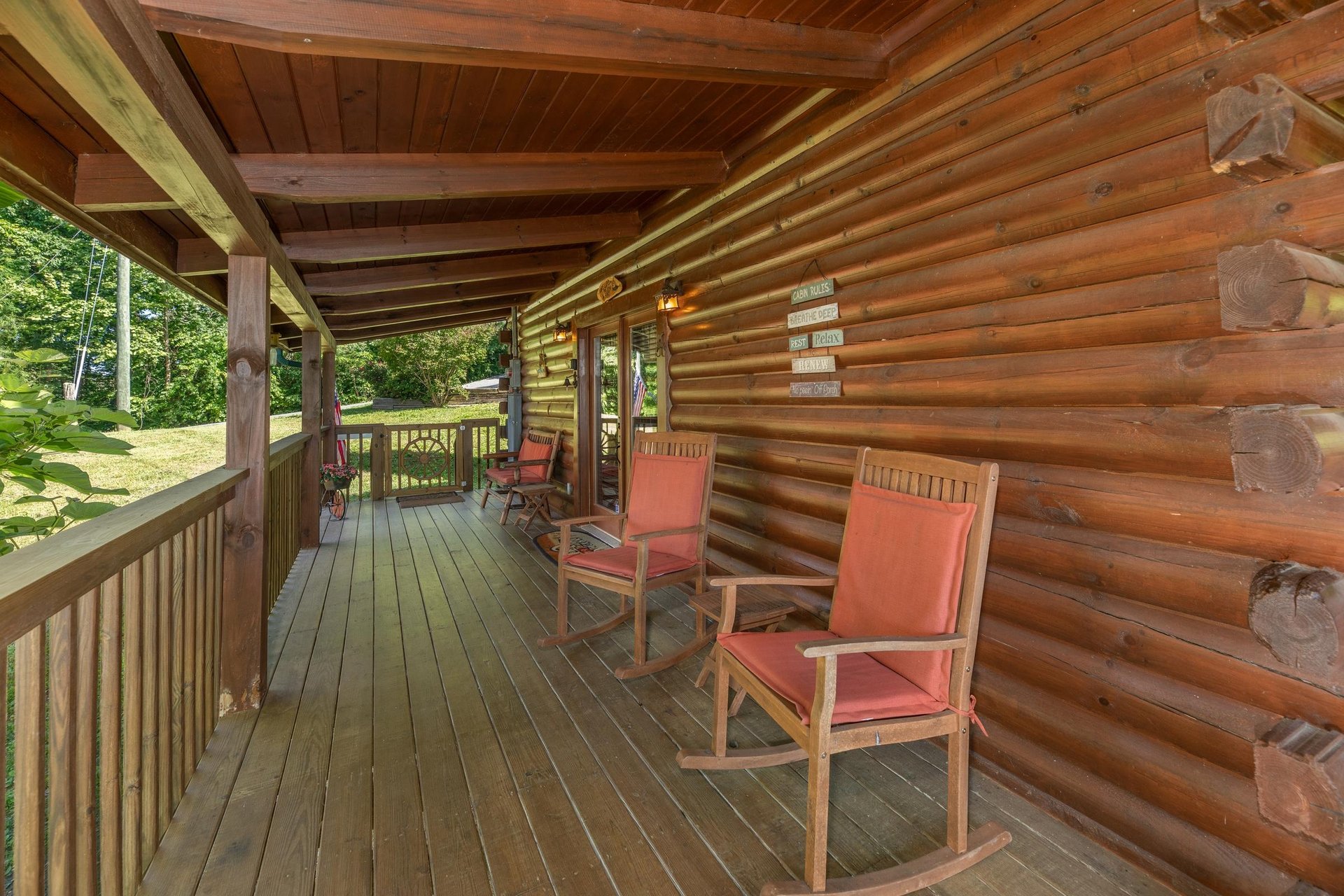 Rocking chairs on a covered deck at Grand View, a 3 bedroom cabin rental located in Sevierville