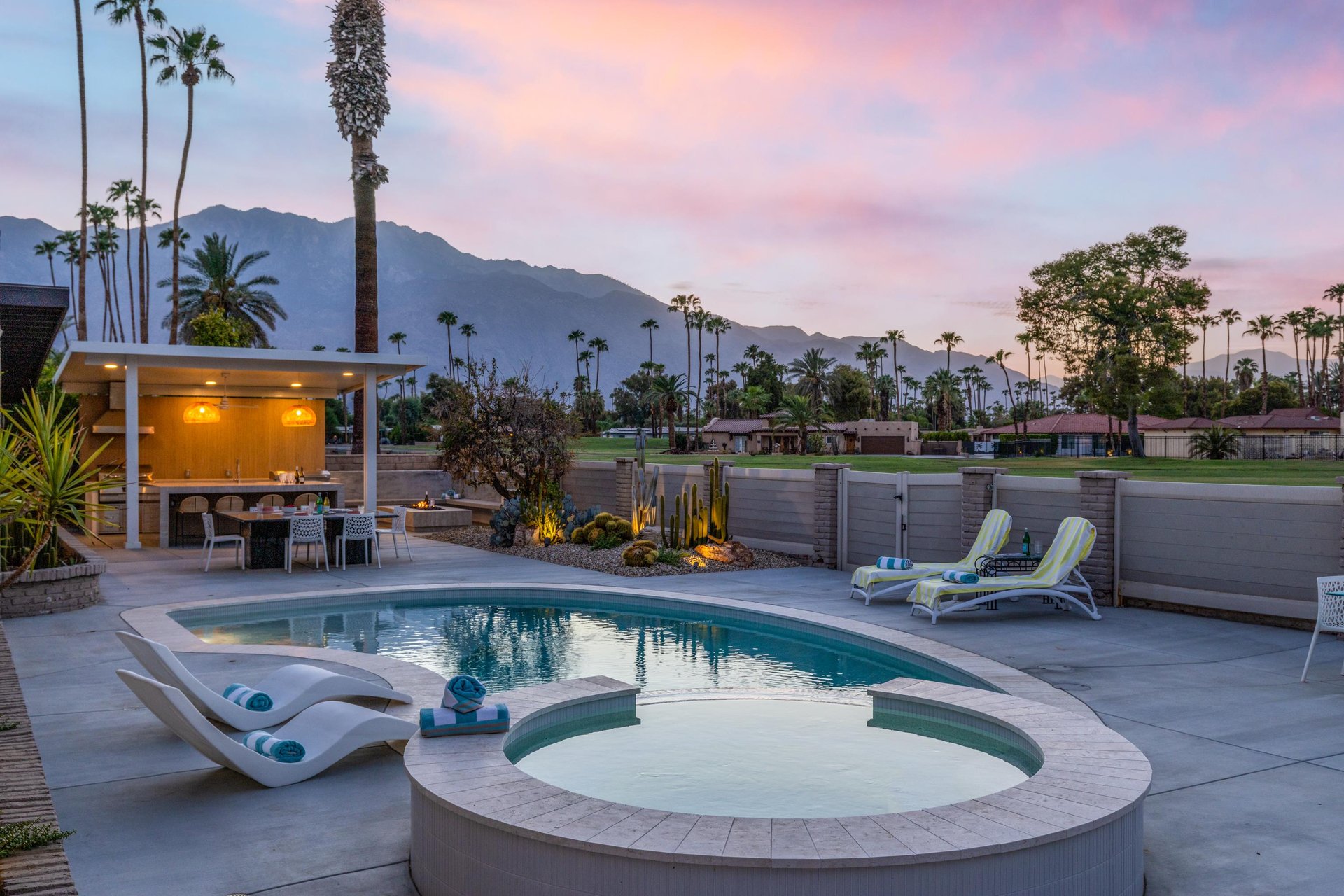 Home looks out onto the golf course with a private pool, spa, firepit, and outdoor kitchen.