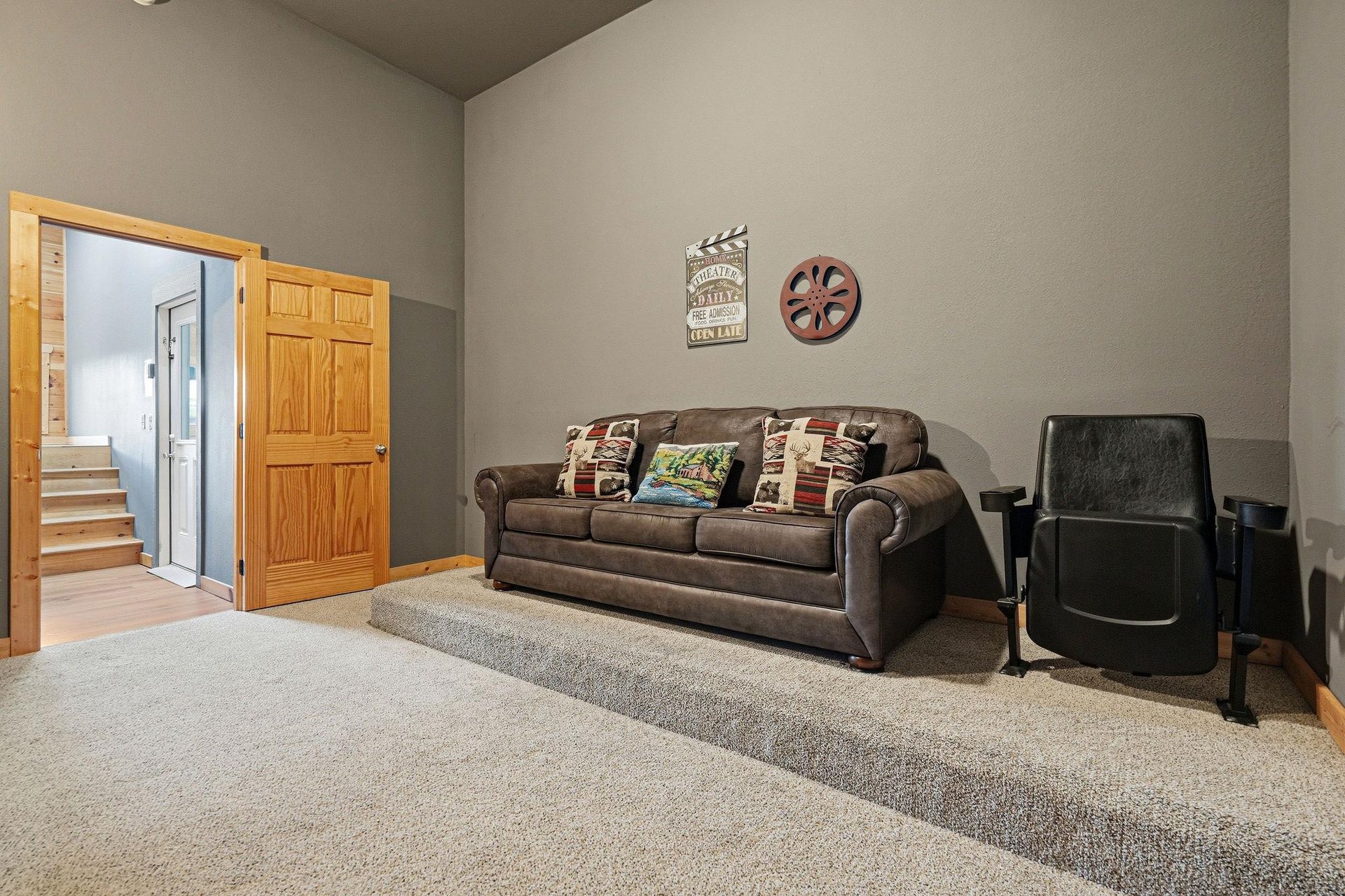 Settle into this cozy living room where a plush sofa and comfortable seating await your movie nights. Charming decor adds character, while soft carpet underfoot creates a welcoming retreat after your 
