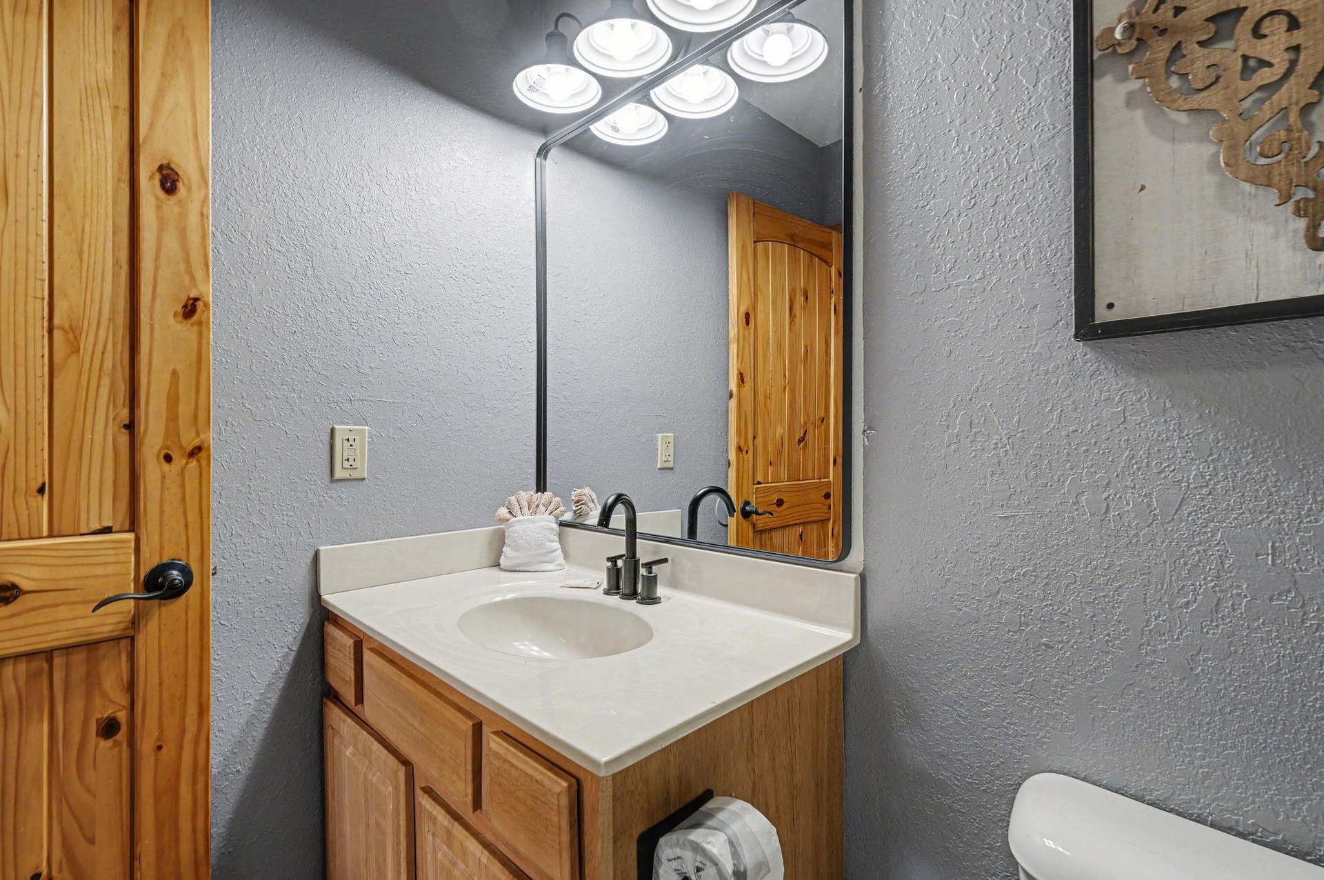 Your private bathroom offers rustic charm with warm wood vanity and fresh towels for your comfort.