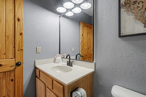 Your private bathroom offers rustic charm with warm wood vanity and fresh towels for your comfort.