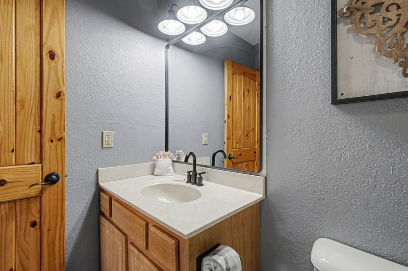 Your private bathroom offers rustic charm with warm wood vanity and fresh towels for your comfort.