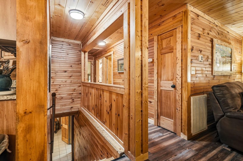 Step into a warm, inviting hallway with rich wood paneling and charming cabin details that welcome you home after a day of adventure.